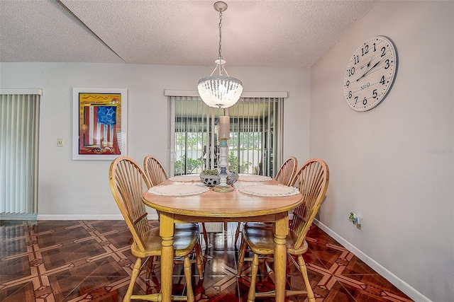 dining room with baseboards, a textured ceiling, and a chandelier