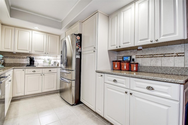 kitchen with freestanding refrigerator, decorative backsplash, white cabinets, and ornamental molding