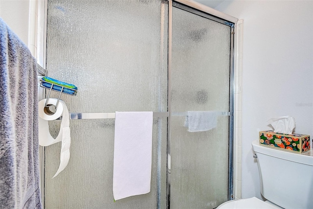 full bathroom with a shower stall and toilet