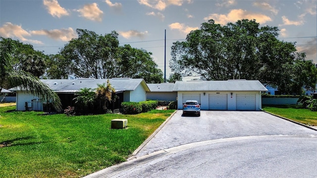single story home featuring a front lawn and asphalt driveway