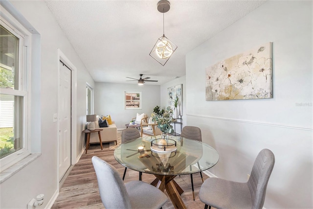 dining space with baseboards, light wood finished floors, and ceiling fan