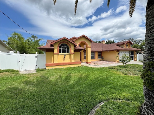 mediterranean / spanish house featuring a gate, fence, a garage, and stucco siding