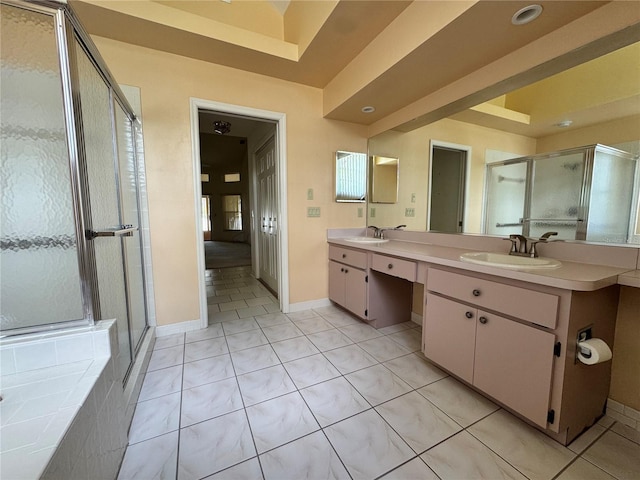 full bathroom featuring a sink, double vanity, a shower stall, and tile patterned floors