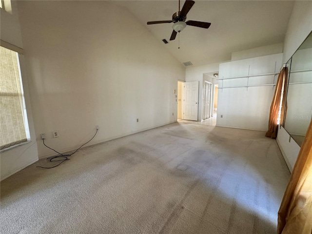 unfurnished bedroom featuring a ceiling fan, visible vents, high vaulted ceiling, and light colored carpet