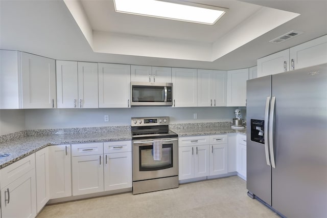 2115 N Halcyon Dr Unit 510, Sun City Center, FL 33573 - kitchen featuring stainless steel appliances, a raised ceiling, white cabinetry, and light stone counters
