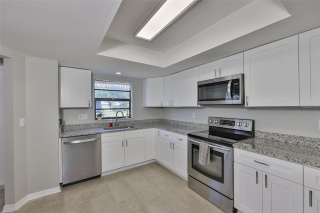 2115 N Halcyon Dr Unit 510, Sun City Center, FL 33573 - kitchen with stainless steel appliances, a sink, a tray ceiling, white cabinetry, and light stone counters