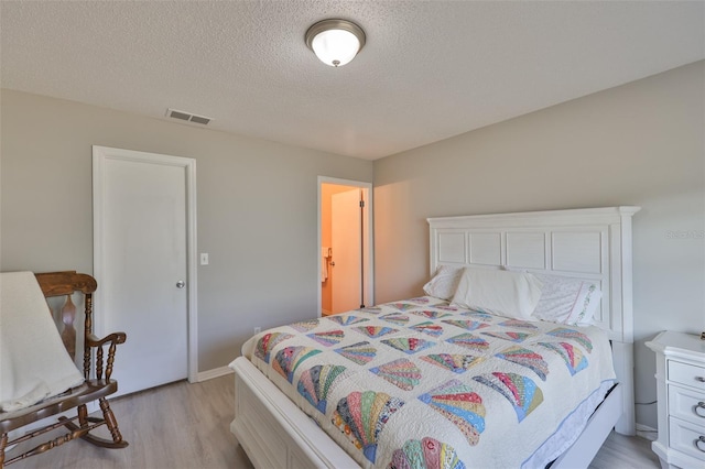 2115 N Halcyon Dr Unit 510, Sun City Center, FL 33573 - bedroom with light wood-type flooring, a textured ceiling, and baseboards