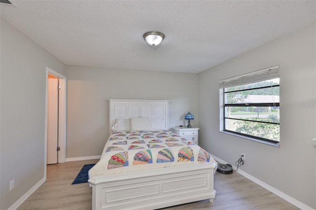 2115 N Halcyon Dr Unit 510, Sun City Center, FL 33573 - bedroom featuring light wood-style floors, baseboards, and a textured ceiling
