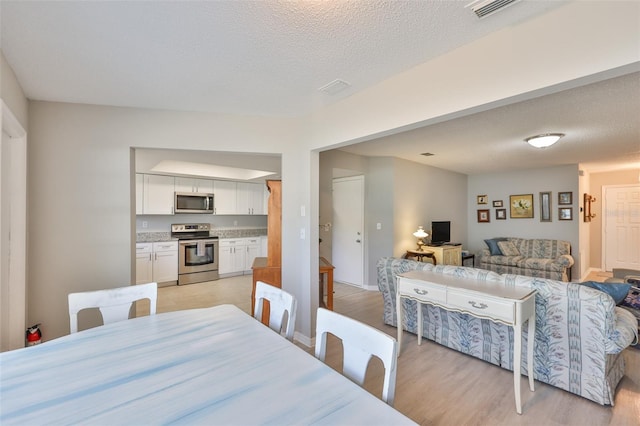 2115 N Halcyon Dr Unit 510, Sun City Center, FL 33573 - dining space featuring light wood-style flooring and a textured ceiling