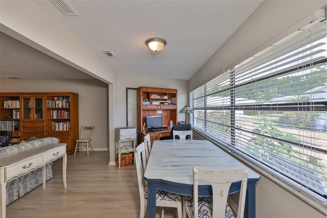 2115 N Halcyon Dr Unit 510, Sun City Center, FL 33573 - dining area with a textured ceiling, light wood-type flooring, and baseboards