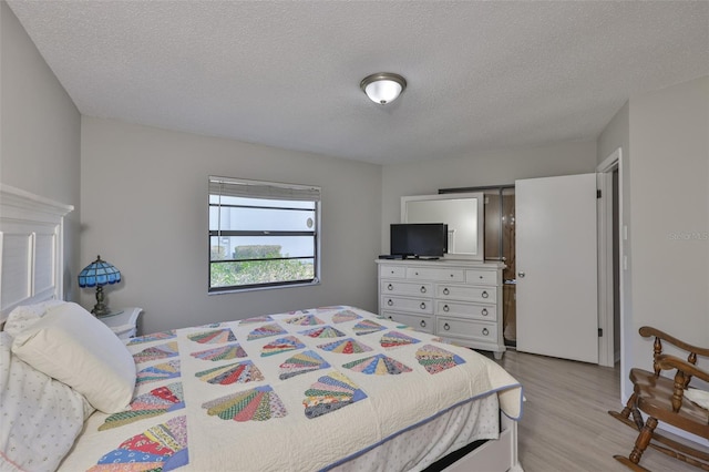 2115 N Halcyon Dr Unit 510, Sun City Center, FL 33573 - bedroom with light wood finished floors and a textured ceiling