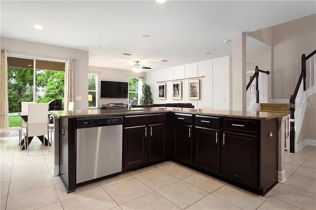 4407 Scarlet Loop, Wesley Chapel, FL 33544 - kitchen featuring stainless steel dishwasher, dark stone countertops, ceiling fan, light tile patterned flooring, and open floor plan