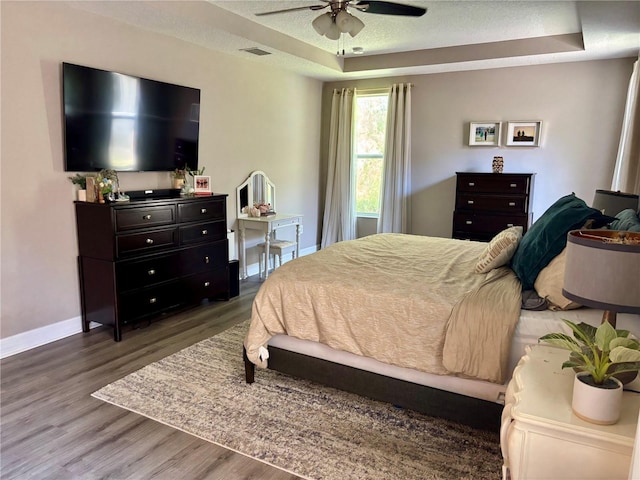 4407 Scarlet Loop, Wesley Chapel, FL 33544 - bedroom featuring a raised ceiling, wood finished floors, baseboards, a textured ceiling, and a ceiling fan