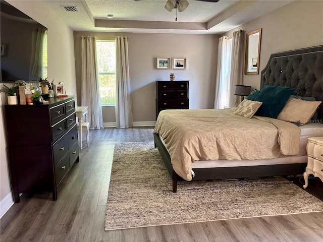 4407 Scarlet Loop, Wesley Chapel, FL 33544 - bedroom featuring a tray ceiling, wood finished floors, baseboards, and a textured ceiling