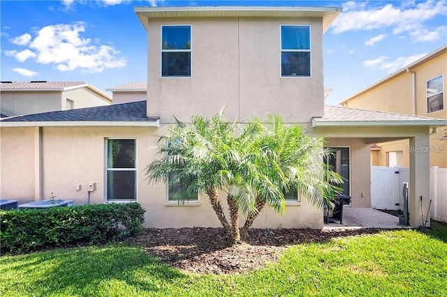4407 Scarlet Loop, Wesley Chapel, FL 33544 - back of house with roof with shingles, stucco siding, and a gate