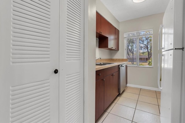 7505 Pitch Pine Cir Unit 122, Tampa, FL 33617 - kitchen with a sink, freestanding refrigerator, stainless steel dishwasher, baseboards, and light countertops
