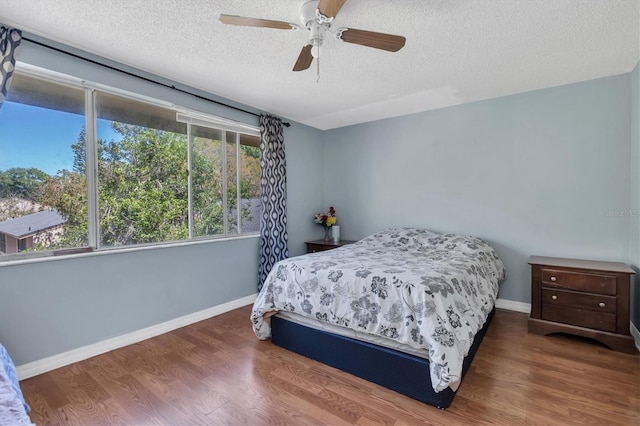 7505 Pitch Pine Cir Unit 122, Tampa, FL 33617 - bedroom with a textured ceiling, wood finished floors, baseboards, and ceiling fan