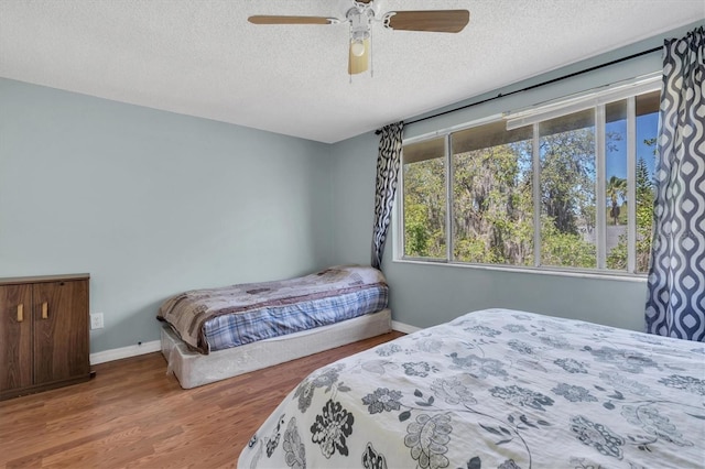 7505 Pitch Pine Cir Unit 122, Tampa, FL 33617 - bedroom featuring a ceiling fan, a textured ceiling, wood finished floors, and baseboards