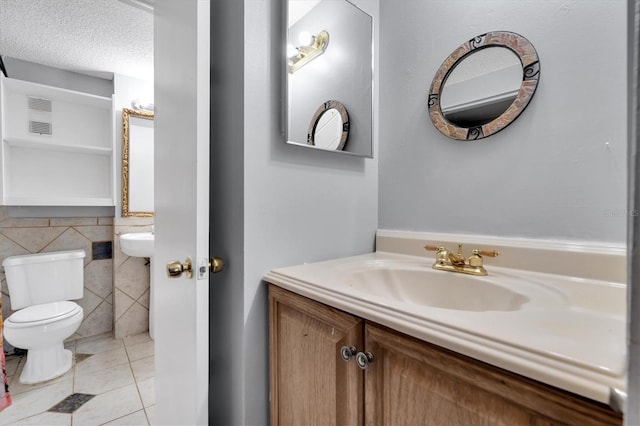 7505 Pitch Pine Cir Unit 122, Tampa, FL 33617 - bathroom with a sink, tile walls, toilet, visible vents, and tile patterned floors