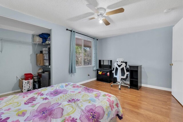 7505 Pitch Pine Cir Unit 122, Tampa, FL 33617 - bedroom with a closet, wood finished floors, a textured ceiling, ceiling fan, and baseboards