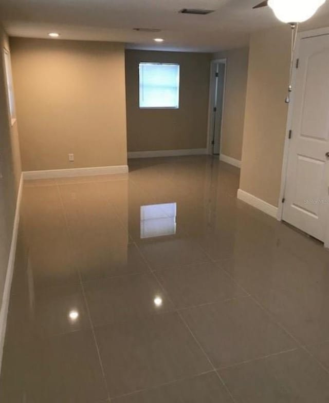 empty room featuring tile patterned floors, baseboards, and recessed lighting