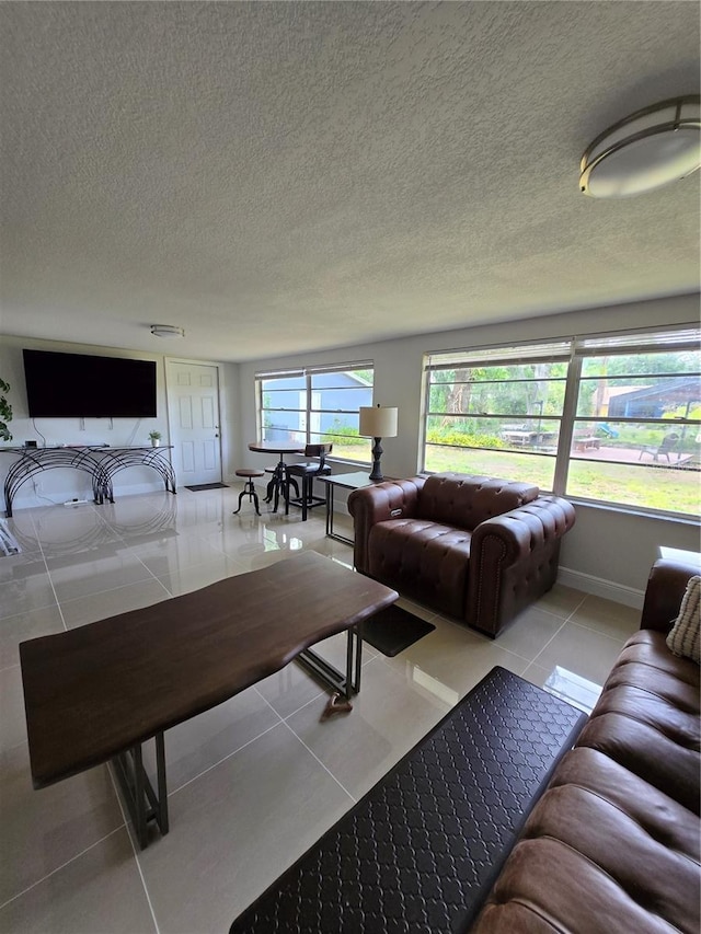 living room featuring tile patterned flooring, a textured ceiling, and baseboards