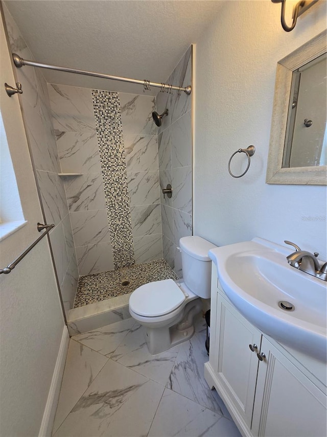 full bathroom featuring marble look tiles, vanity, toilet, a stall shower, and a textured ceiling