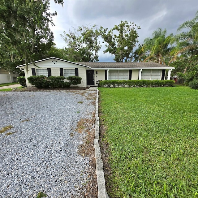 1412 Sunset Ln, Lutz, FL 33549 - ranch-style home with a front yard and gravel driveway
