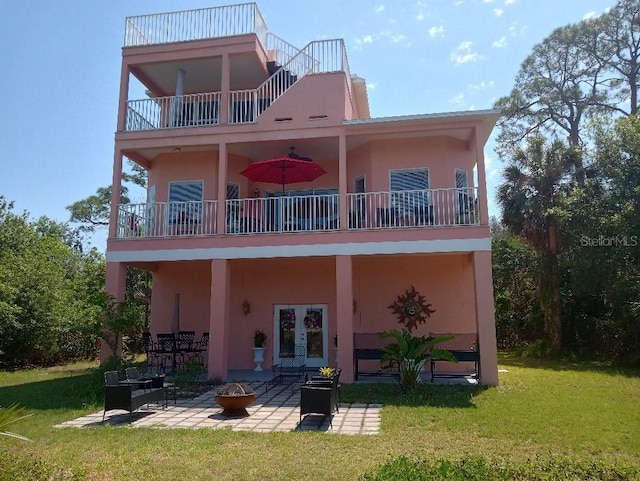 6926 Mccray Dr, Hudson, FL 34667 - rear view of property with a balcony, a patio area, an outdoor fire pit, and a yard