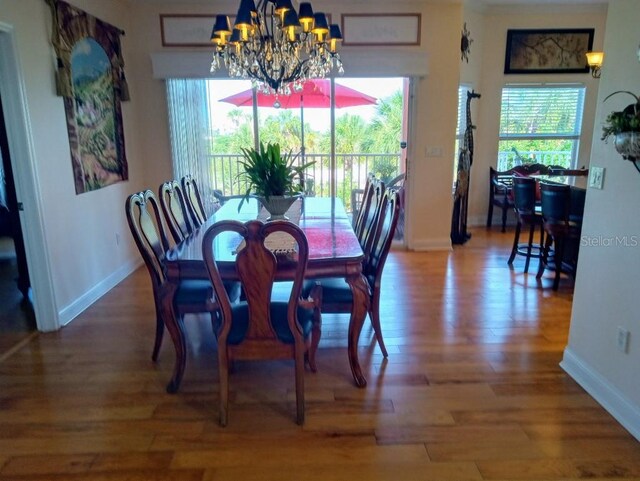 6926 Mccray Dr, Hudson, FL 34667 - dining area featuring a chandelier, plenty of natural light, and wood finished floors