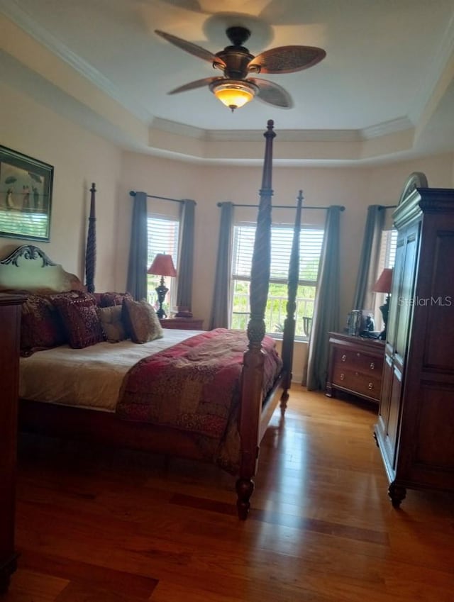 6926 Mccray Dr, Hudson, FL 34667 - bedroom with a tray ceiling, crown molding, light wood-style flooring, and a ceiling fan