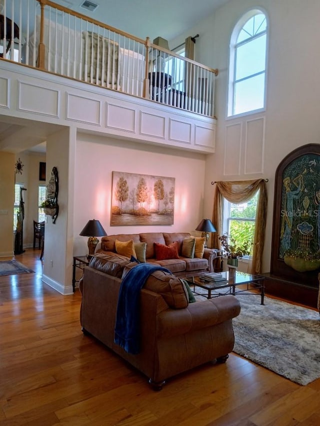 6926 Mccray Dr, Hudson, FL 34667 - living room featuring a towering ceiling, wood finished floors, and baseboards