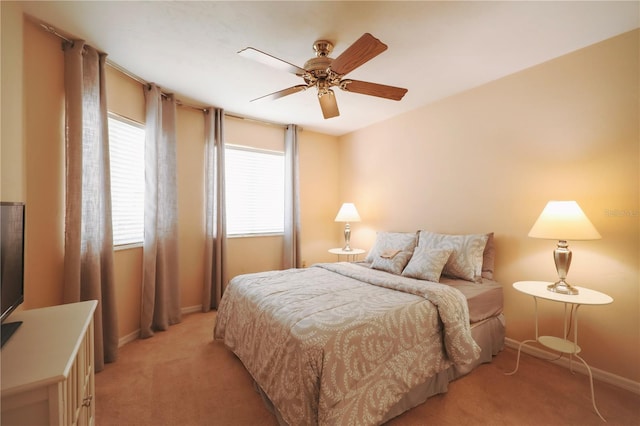 bedroom featuring multiple windows, light carpet, and baseboards