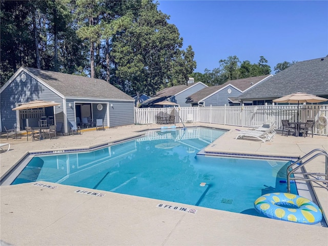 community pool with fence and a patio area