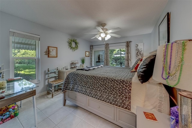 bedroom featuring light tile patterned floors, ceiling fan, and a textured ceiling