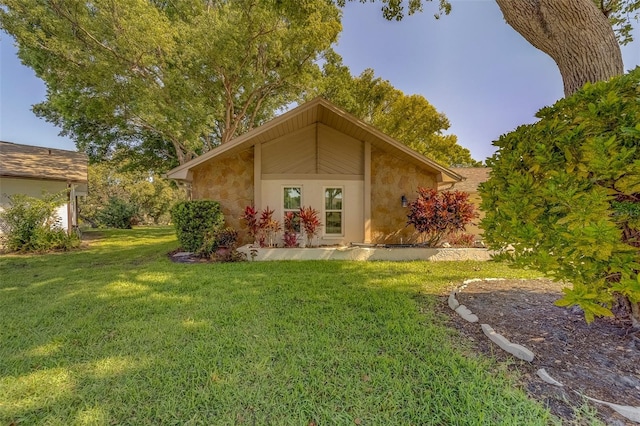 back of property with a lawn and stucco siding