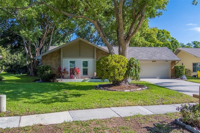 mid-century home featuring a front yard, a garage, and driveway