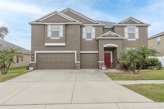 621 Washita Stone Dr, Ruskin, FL 33570 - view of front facade with an attached garage, stone siding, stucco siding, concrete driveway, and a front lawn