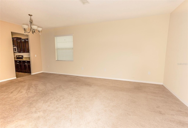 621 Washita Stone Dr, Ruskin, FL 33570 - unfurnished room with light colored carpet, an inviting chandelier, and baseboards
