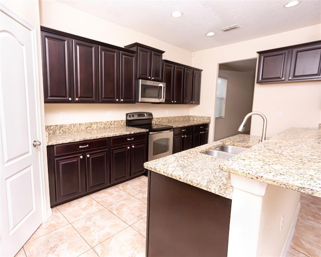 621 Washita Stone Dr, Ruskin, FL 33570 - kitchen featuring light stone countertops, recessed lighting, light tile patterned floors, a sink, and stainless steel appliances