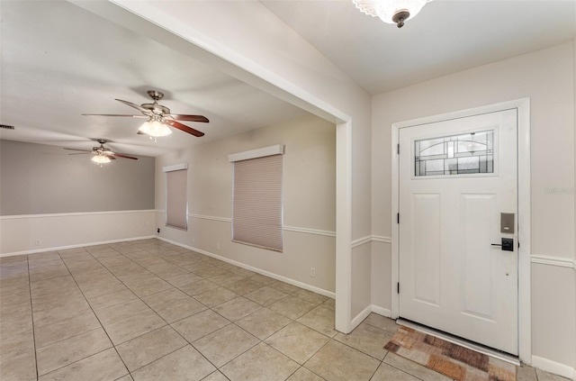 foyer featuring ceiling fan, baseboards, light tile patterned floors, and visible vents