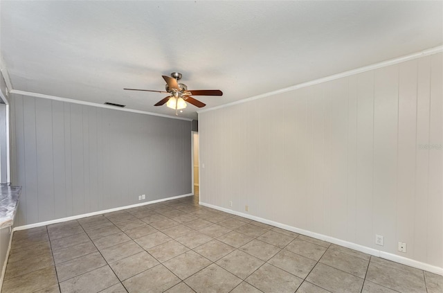 empty room with light tile patterned floors, baseboards, ornamental molding, visible vents, and ceiling fan