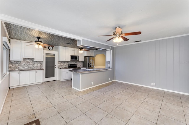 kitchen with stainless steel appliances, ceiling fan, and decorative backsplash
