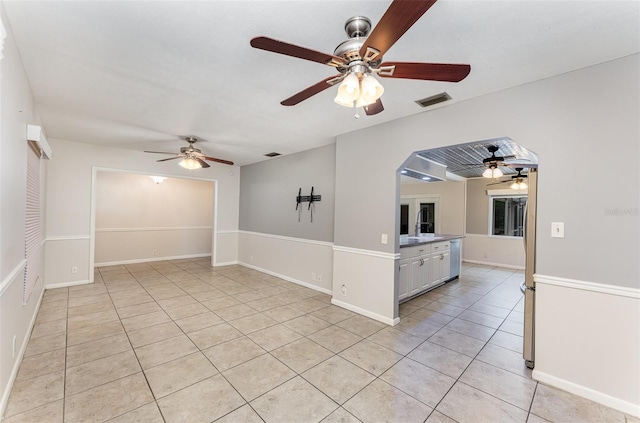 empty room with a ceiling fan, baseboards, visible vents, and light tile patterned flooring