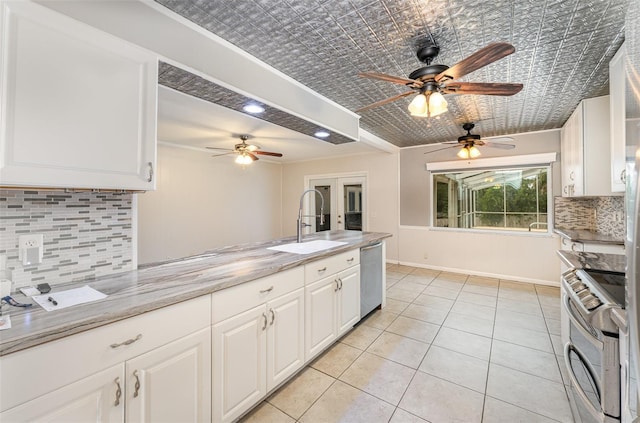 kitchen with a ceiling fan, french doors, a sink, backsplash, and appliances with stainless steel finishes