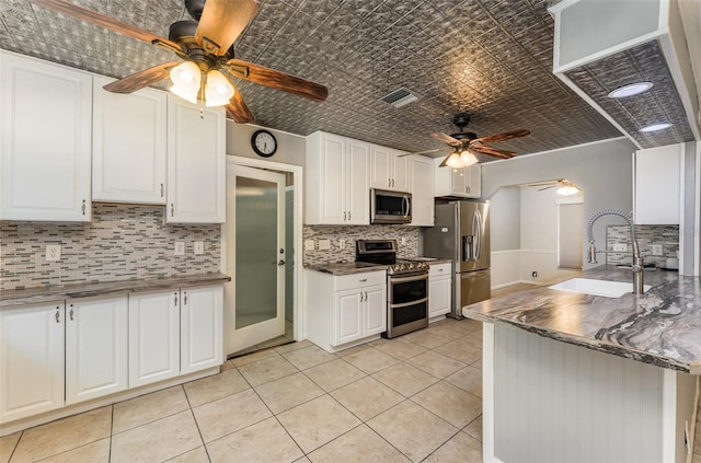 kitchen featuring a sink, white cabinetry, ceiling fan, appliances with stainless steel finishes, and decorative backsplash