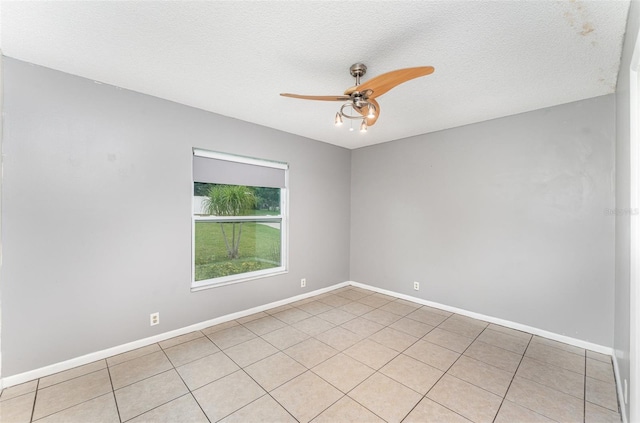 unfurnished room featuring light tile patterned floors, baseboards, a ceiling fan, and a textured ceiling