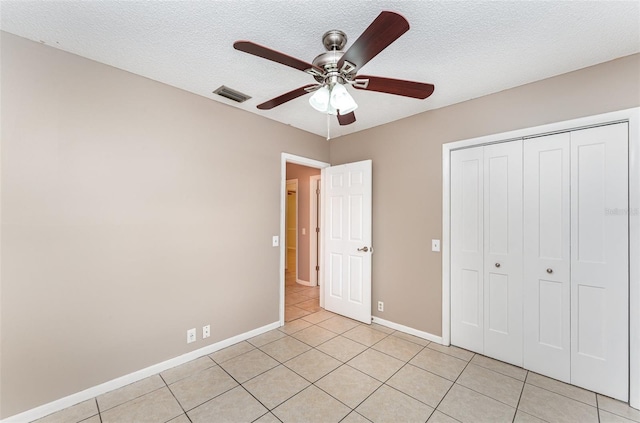 unfurnished bedroom featuring light tile patterned floors, baseboards, a closet, and visible vents