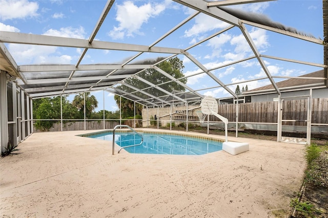 outdoor pool with glass enclosure, a patio, and fence