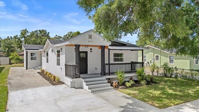 3215 E Powhatan Ave, Tampa, FL 33610 - view of front of house featuring a porch, stucco siding, and driveway